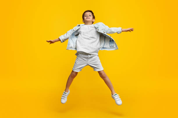istock Stylish boy leaping up and stretching out arms 1154728740