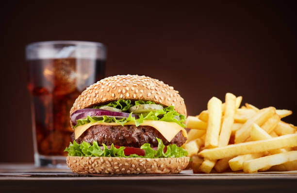 cheeseburger con cola e patatine fritte - burger french fries cheeseburger hamburger foto e immagini stock