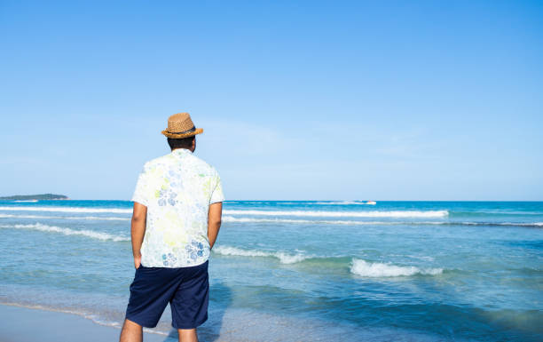 istock Rear view happy young asian man on the tropical beach. 1154731995