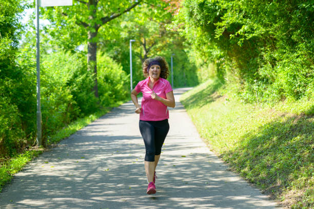 istock Fit middle-aged woman out jogging in spring 1154732168