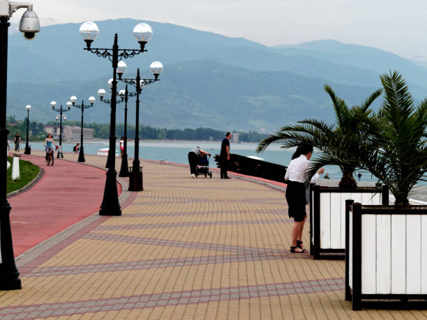Sochi, Russia - May 18, 2019: a young woman is looking for something in her purse on the embankment