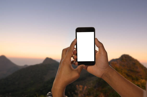 istock Hands holding mockup smartphone with empty screen on landscape nature background. 1154744539