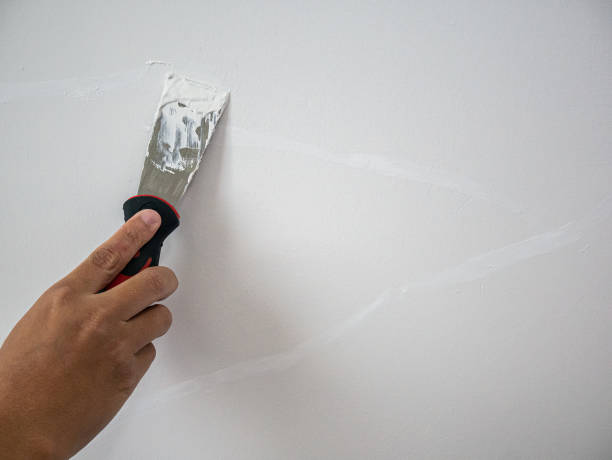 plasterer riparazione mano crack muro bianco - plaster putty cement decorating foto e immagini stock