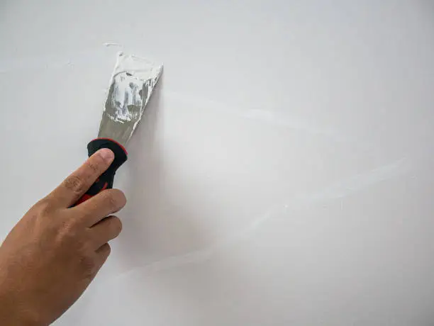 Plasterer hand repair crack white wall