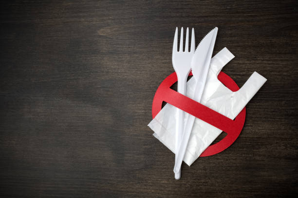 istock White plastic tableware on a wooden background as a symbol of environmental pollution. Ban single use plastic. 1154748202