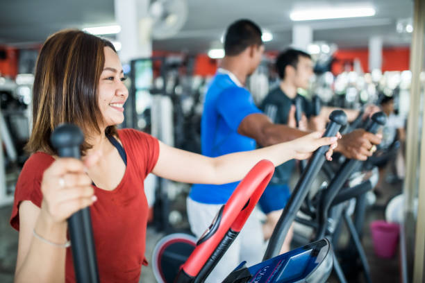 istock Three people exercising on cross trainer in the gym 1154754128