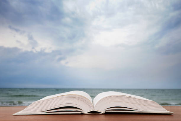 istock Open book over the landscape background 1154754157
