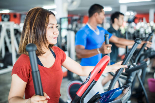 istock Three people exercising on cross trainer in the gym 1154754201