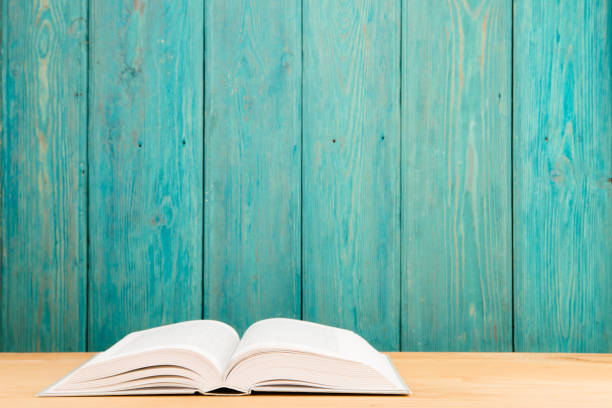 Open book on the desk over wooden background