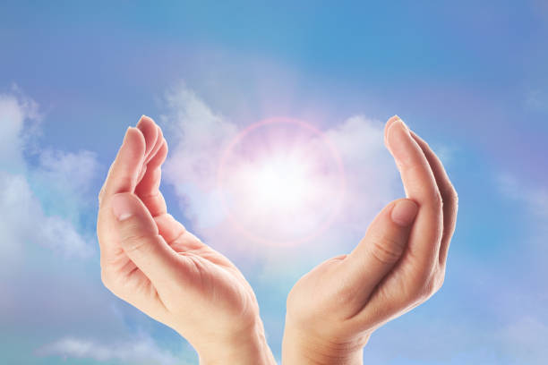 istock Healing hands with bright sunburst on rainbow background 1154754473