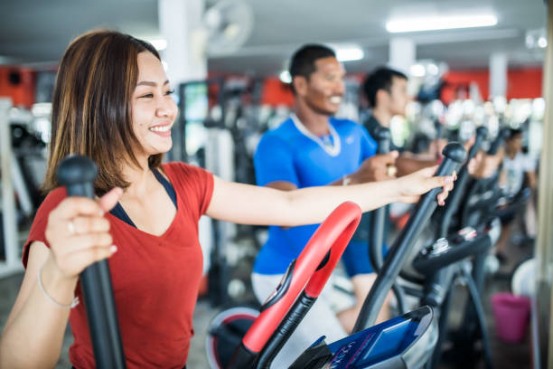 istock Three people exercising on cross trainer in the gym 1154755083