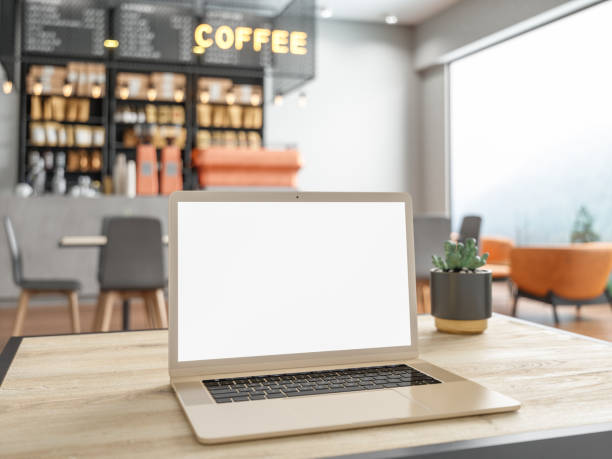istock Laptop with blank screen on table with cafe backgrounds 1154755262