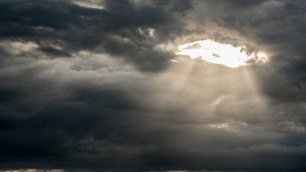 istock The sun's rays shine through a hole in the continuous cloud cover 1154755432