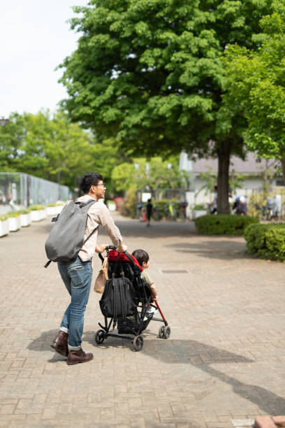 istock Father pushing baby stroller in park 1154756450