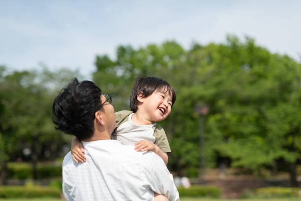 Supportive father playing with son Father playing with toddler on grass only japanese stock pictures, royalty-free photos & images