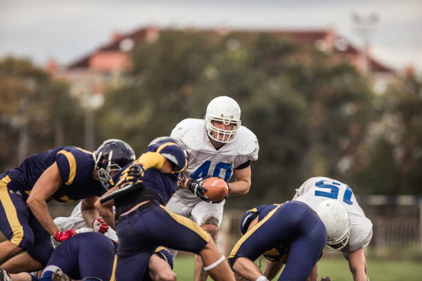 jogador de futebol americano determinado durante um fósforo em jogar o campo. - football player group of people running american football - fotografias e filmes do acervo