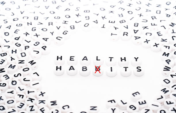 istock Healthy Habits spelled wrong text written with white blocks dice with black text top down view with a red cross to fix the error 1154758622