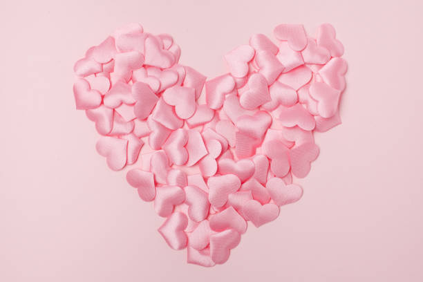 istock Heart shape pink confetti splash on pink background 1154759412