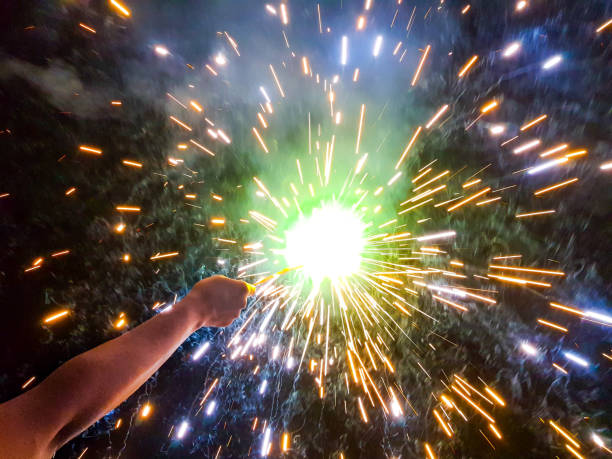 istock hand charki, a  hand firework emitting circular sparks in black background 1154759769