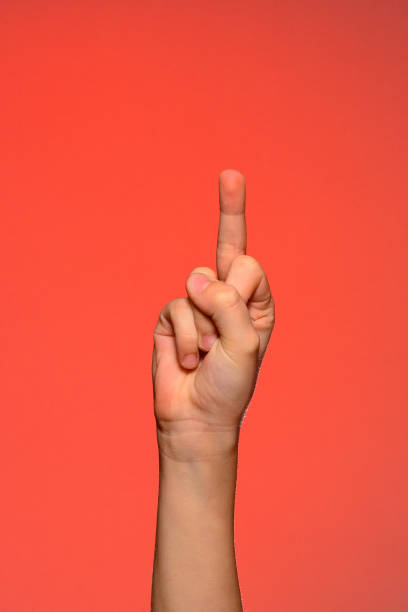 istock Human hand showing an obscene gesture with a middle finger isolated on a red background. 1154759909