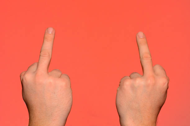Human hand showing an obscene gesture with a middle finger isolated on a red background 2019