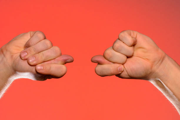 istock Man's hand with a fig's sign close-up is isolated on a red background 1154760669