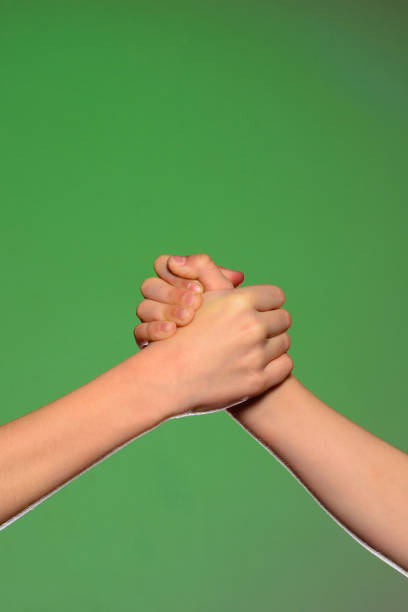 Low angle view of unrecognizable children  shaking hands in the park.