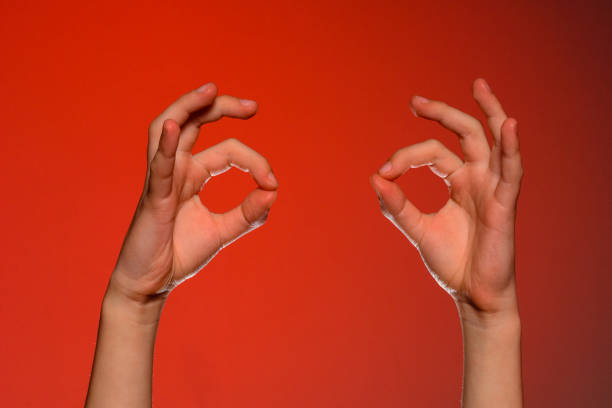 istock Two human hands show a sign ok, isolated on a red background 1154761033