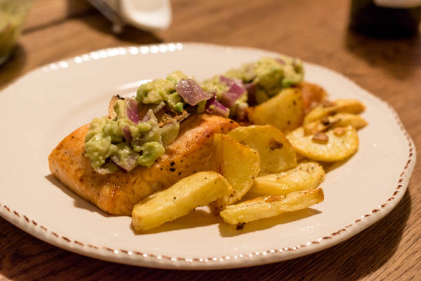 istock Salmon Fillet with Avocado in Plate at Dinner Table. 1154761207