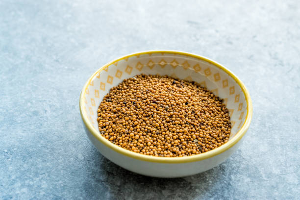 istock Yellow Mustard Seeds in Small Porcelain Bowl. 1154762012