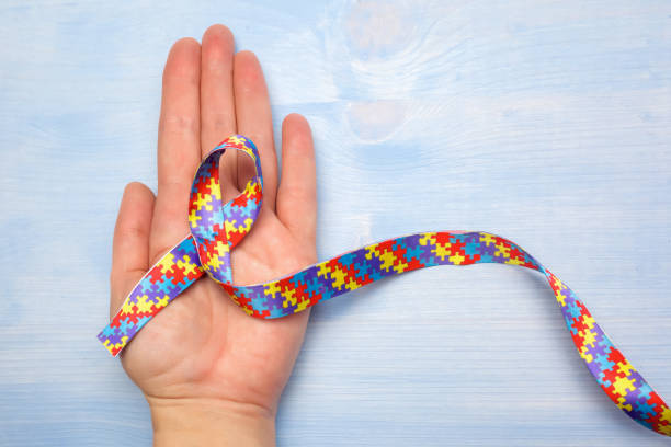istock World Autism awareness and pride day with Puzzle pattern ribbon on hand 1154762038