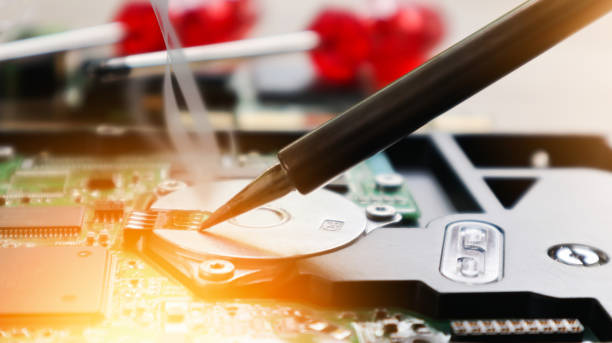 istock image technician repairing inside of hard disk by soldering iron. Integrated Circuit. the concept of data, hardware, technician and technology. 1154765197