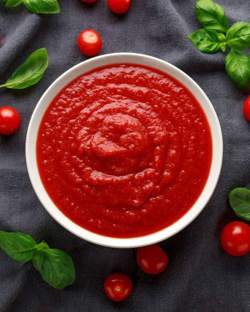 hausgemachte tomate passata in weißer schüssel mit basilikum - tomatensoße stock-fotos und bilder