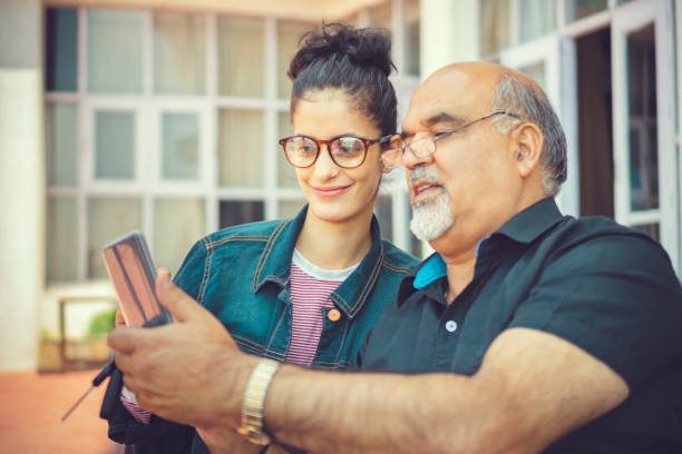 istock Senior man takes help in smartphone from a young woman. 1154765925