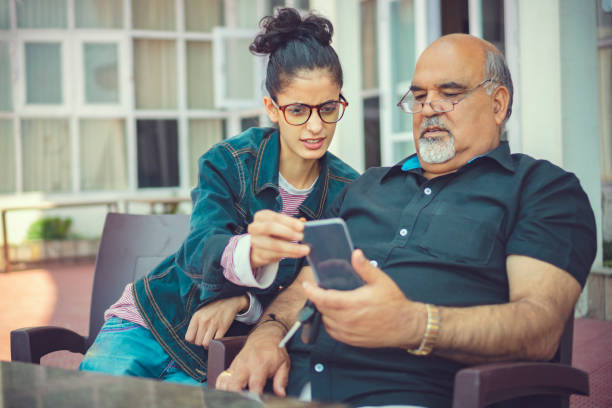istock Senior man takes help in smartphone from a young woman. 1154765964