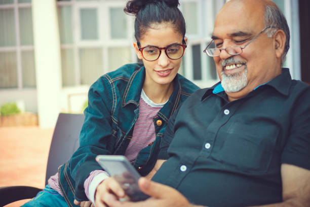 istock Senior man takes help in smartphone from a young woman. 1154765991