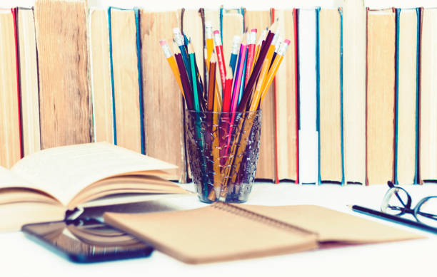 istock Open textbook, notebook, smartphone, stack of books education back to school background, glasses and pencils in plastic holder with copy space for text 1154766234