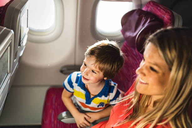 istock Happy boy and his mother watching something on device screen in an airplane. 1154766424