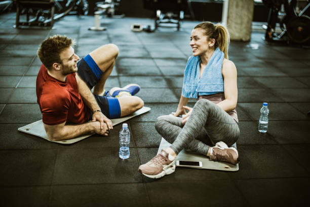 istock Happy athletic couple talking on water break in a gym. 1154770368