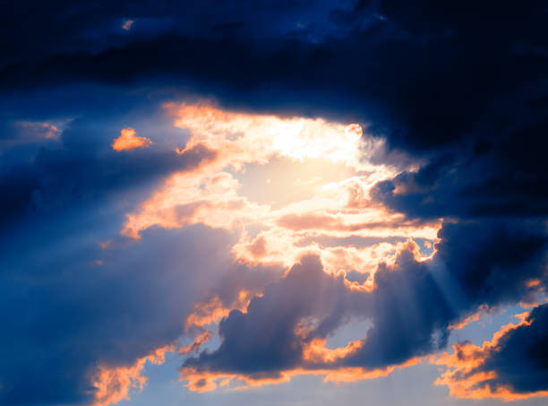Dramatic light rays at cloud clearing background stock photo