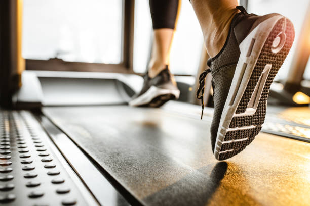 체육관에서 러닝 머신에서 달리는 인식 되지 않는 선수의 클로즈업. - treadmill 뉴스 사진 이미지