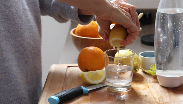 woman lemon water kitchen