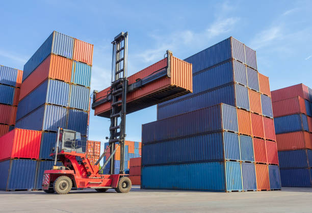 istock Forklift handling container box loading to truck in shipping yard with cargo container background, Logistic industrial concept. 1154772600