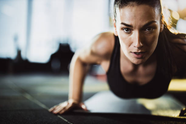 istock Determined athletic woman exercising push-ups in a gym. 1154772694