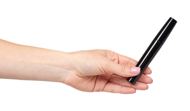 istock Hand with black mascara, eye makeup brush. 1154774656