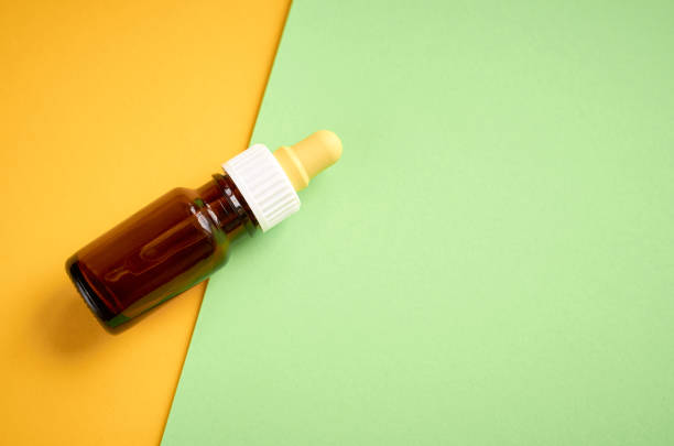 istock Nasal drops bottle composition, glass bottle on yellow and green background 1154774982