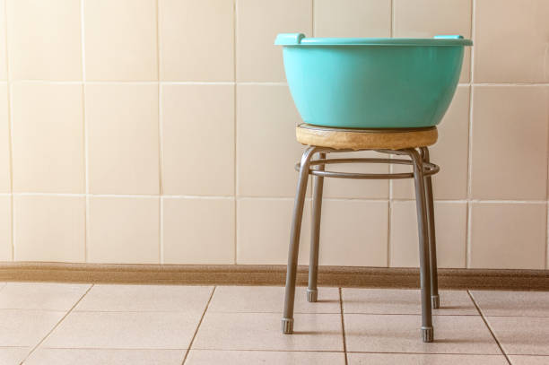 green basin on a chair against the background of an old tile indoors