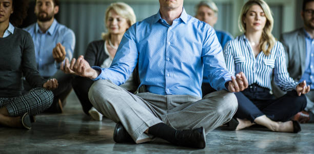 panoramic view of business people exercising yoga on the floor in the office. - yoga meditating business group of people imagens e fotografias de stock