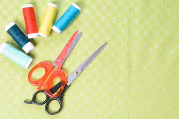 Scissors and threads on fabric, top view Tailoring equipment 2018
