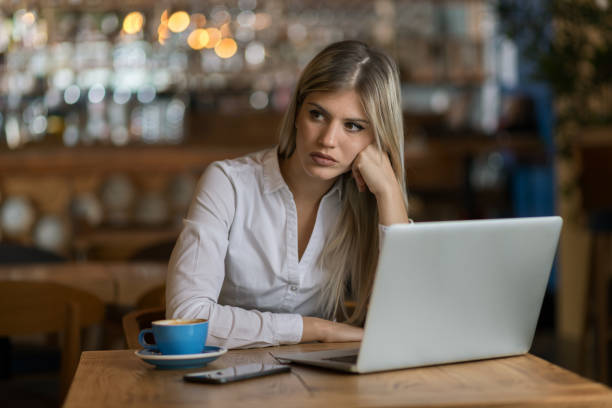 istock Worried businesswoman using laptop in cafeteria 1154782053